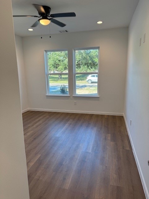 empty room with ceiling fan and dark wood-type flooring