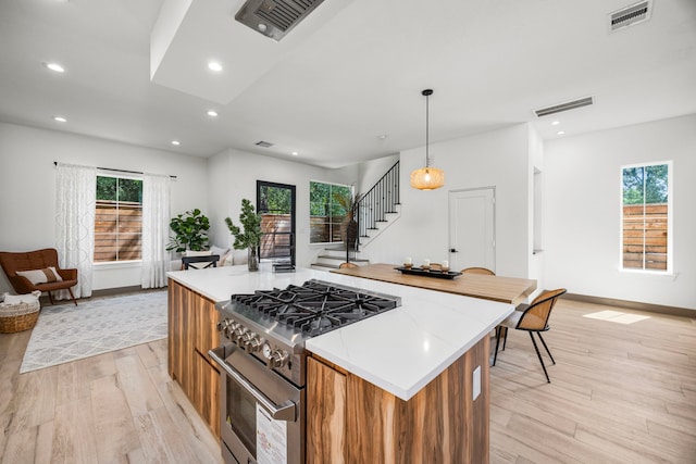 7934 Hennessy Ln Unit 6, Spring, TX 77389 - kitchen featuring stainless steel range, light wood-style floors, a kitchen island, plenty of natural light, and recessed lighting