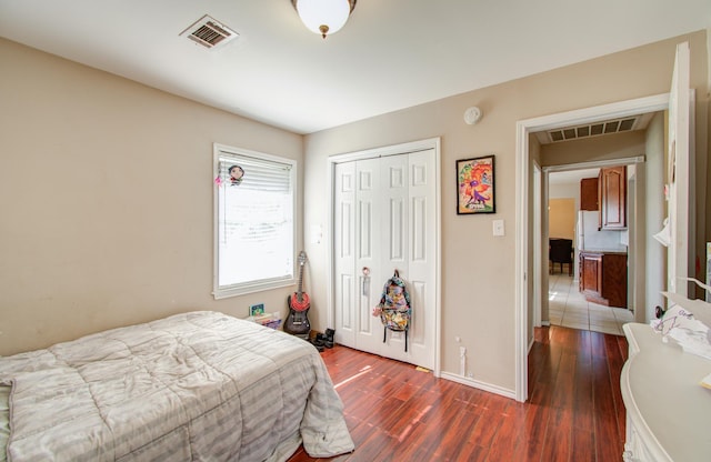 bedroom with dark hardwood / wood-style flooring and a closet