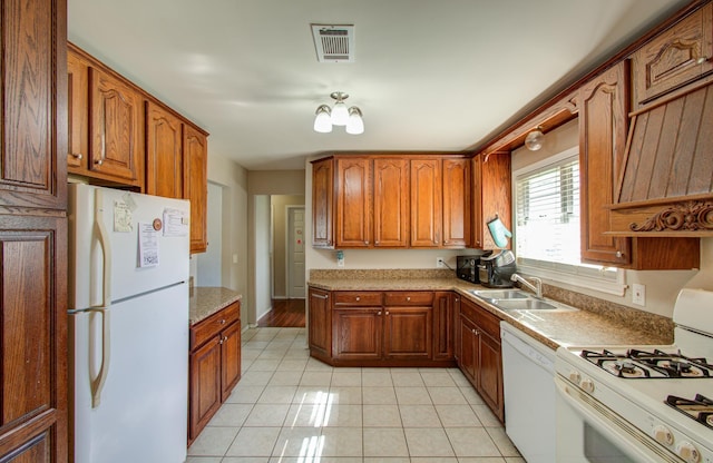 kitchen with sink, light tile patterned floors, and white appliances