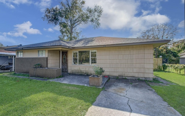 single story home with a front lawn and a patio