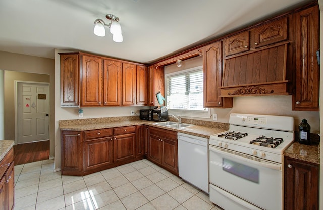 kitchen with light tile patterned flooring, white appliances, and sink