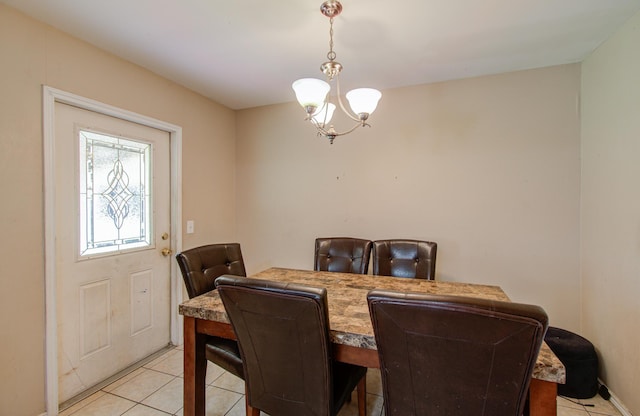 dining space featuring light tile patterned floors and a chandelier