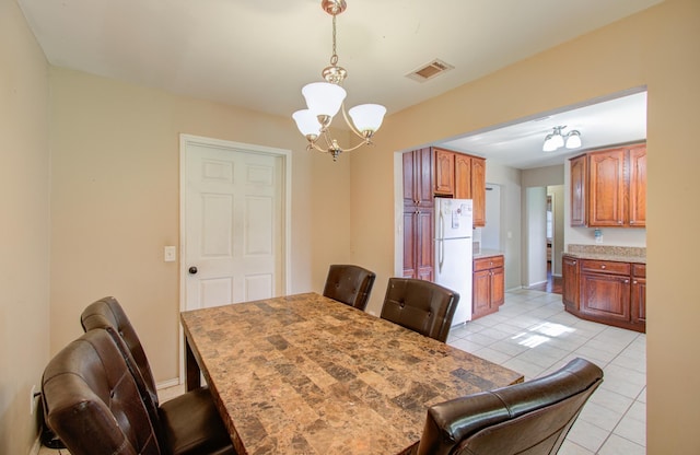 dining space featuring light tile patterned floors and an inviting chandelier