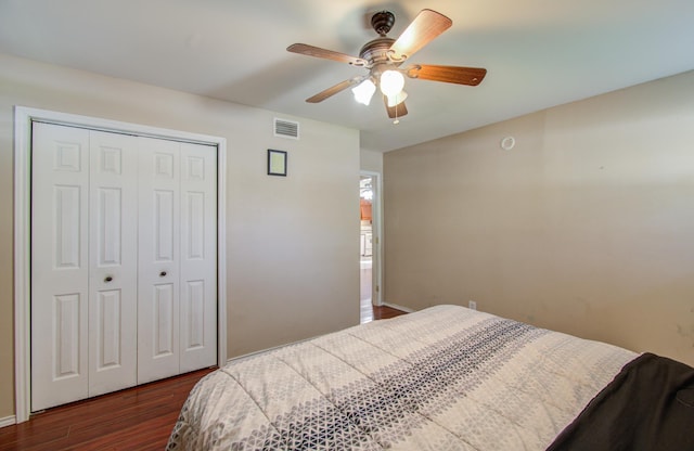 bedroom featuring ceiling fan, a closet, and dark wood-type flooring