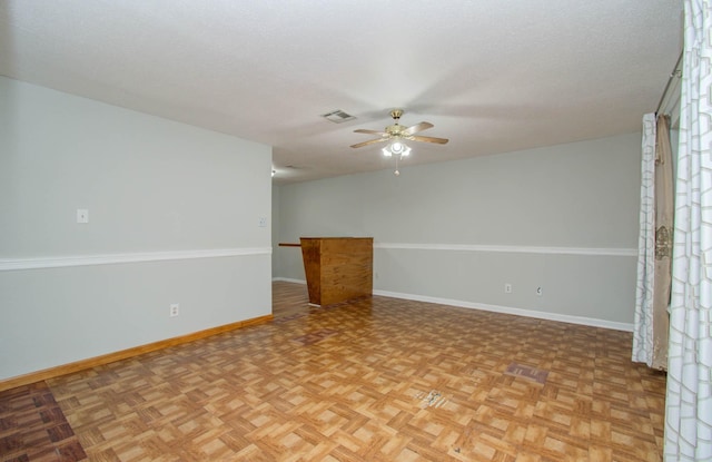 empty room featuring ceiling fan, a textured ceiling, and light parquet flooring