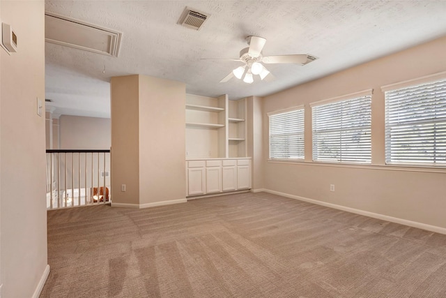 unfurnished room with light carpet, ceiling fan, and a textured ceiling