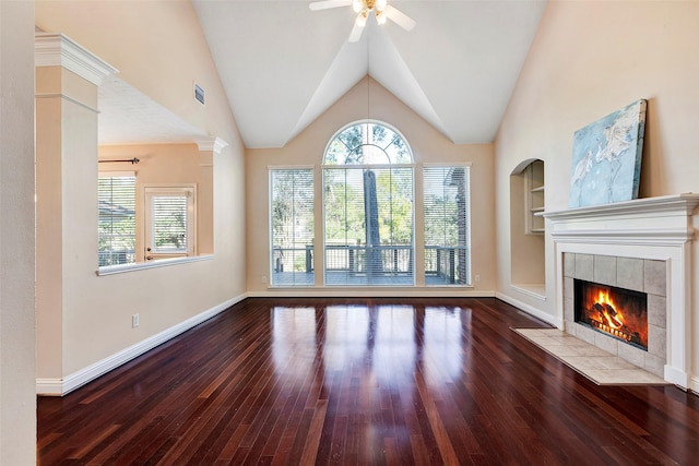 unfurnished living room featuring vaulted ceiling, ceiling fan, a tile fireplace, wood-type flooring, and built in features