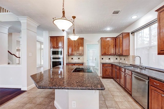 kitchen featuring a center island, stainless steel appliances, dark stone counters, and sink