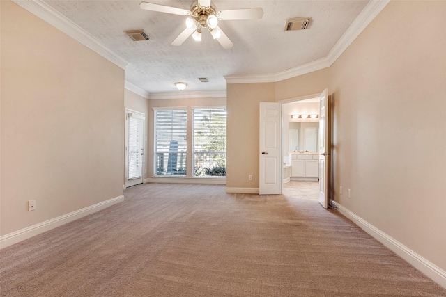 carpeted spare room featuring crown molding, ceiling fan, and a textured ceiling