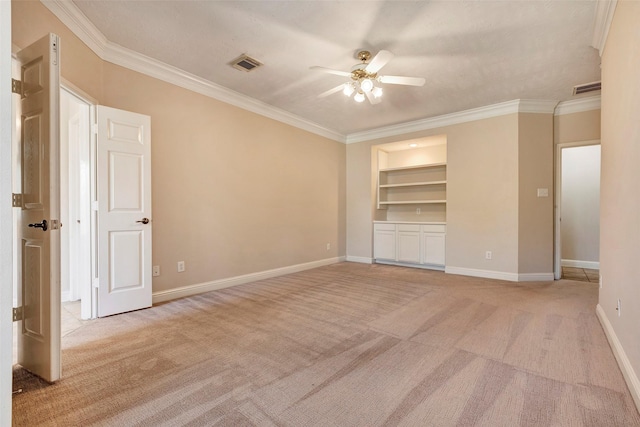 empty room featuring crown molding and light carpet