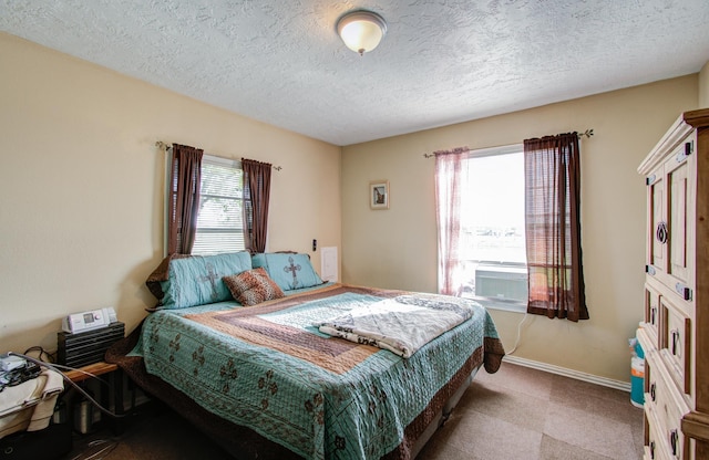 bedroom featuring multiple windows, cooling unit, and a textured ceiling