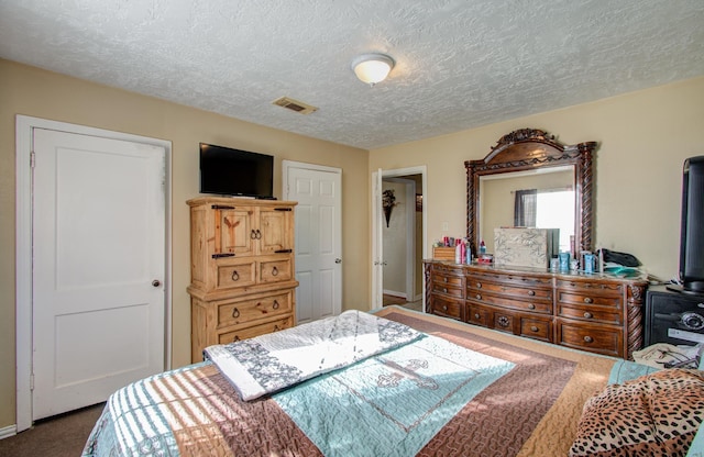 bedroom with carpet floors and a textured ceiling