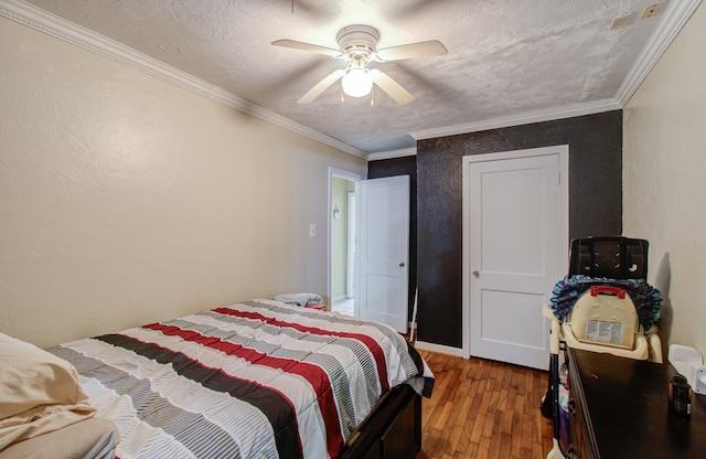 bedroom featuring hardwood / wood-style flooring, ornamental molding, ceiling fan, and a textured ceiling