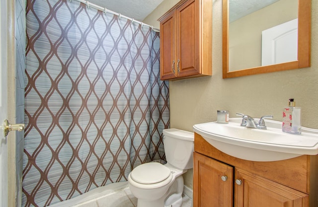 bathroom featuring vanity, a textured ceiling, and toilet