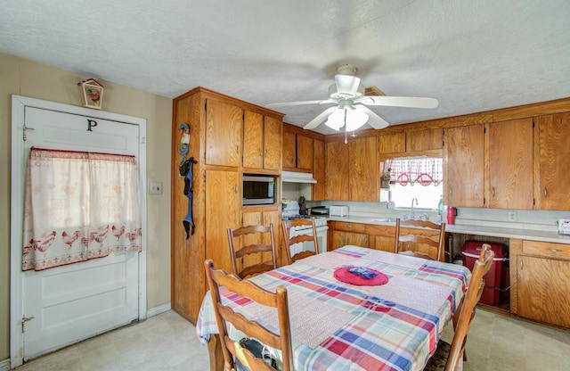 kitchen with sink, a textured ceiling, white gas range oven, and ceiling fan