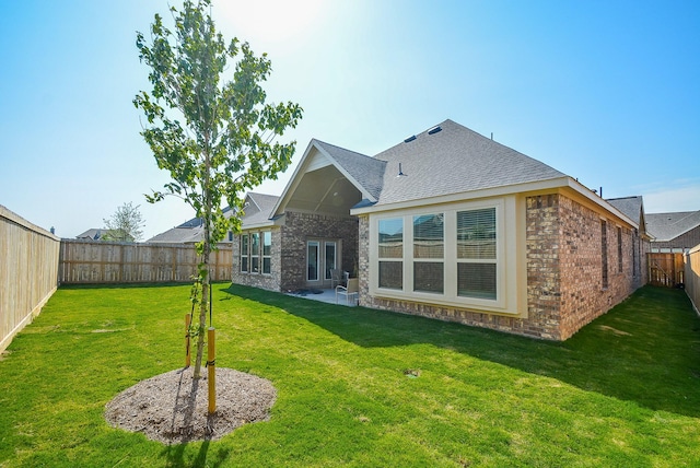 back of property with a patio area and a yard