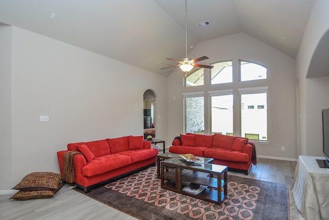 living room featuring ceiling fan, high vaulted ceiling, and wood-type flooring