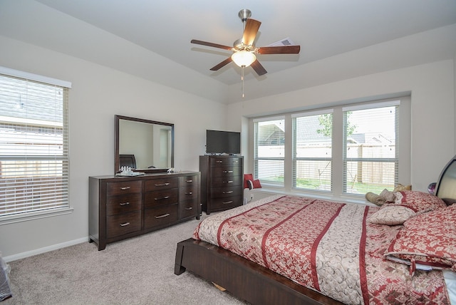 bedroom featuring multiple windows, ceiling fan, and light colored carpet