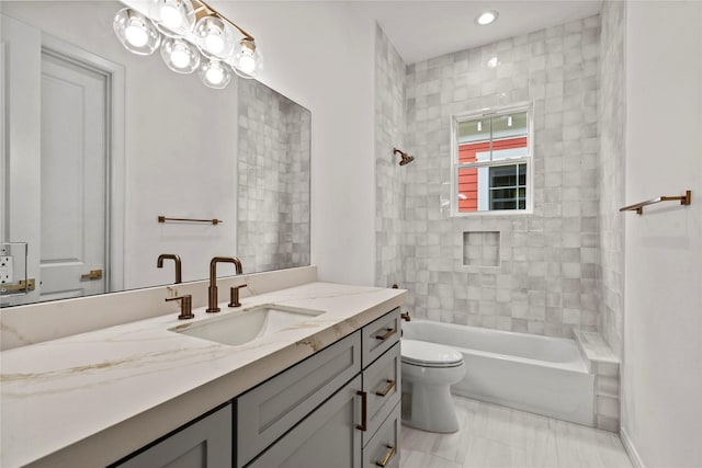 full bathroom with vanity, tiled shower / bath combo, and toilet