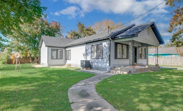 bungalow-style home with central air condition unit, covered porch, and a front yard