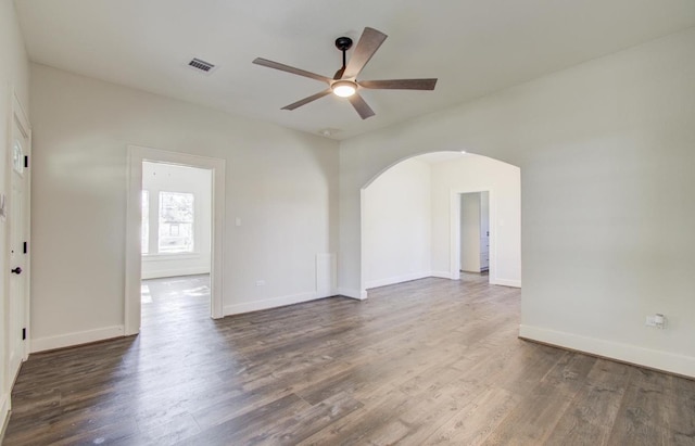 empty room with dark hardwood / wood-style floors and ceiling fan