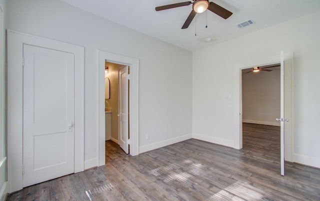 unfurnished bedroom featuring ceiling fan, wood-type flooring, and ensuite bath