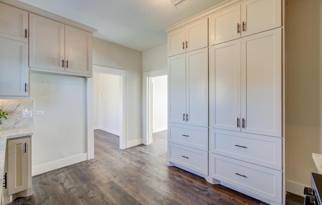 kitchen with dark hardwood / wood-style floors and light stone counters