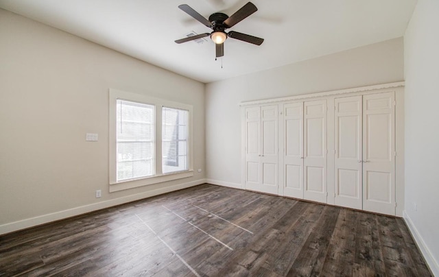 unfurnished bedroom with a closet, dark hardwood / wood-style floors, and ceiling fan