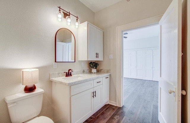 bathroom featuring hardwood / wood-style flooring, vanity, and toilet