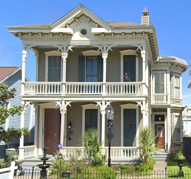 italianate home featuring a porch and a balcony