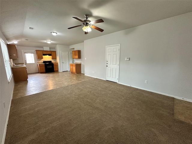 unfurnished living room featuring dark carpet and ceiling fan