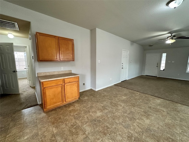 kitchen with ceiling fan, dark carpet, and a textured ceiling