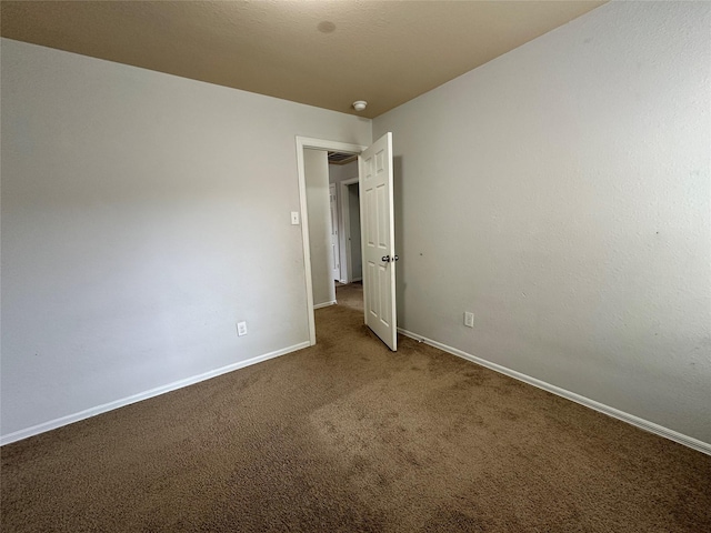 spare room featuring dark carpet