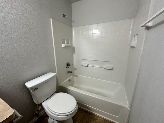 bathroom featuring tile patterned flooring, bathing tub / shower combination, and toilet