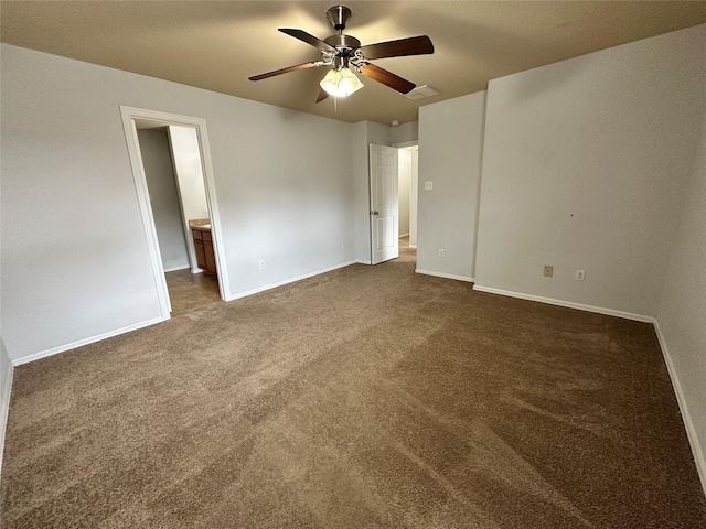 spare room featuring dark colored carpet and ceiling fan