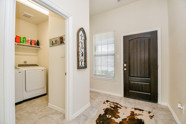 tiled entrance foyer featuring washer and dryer