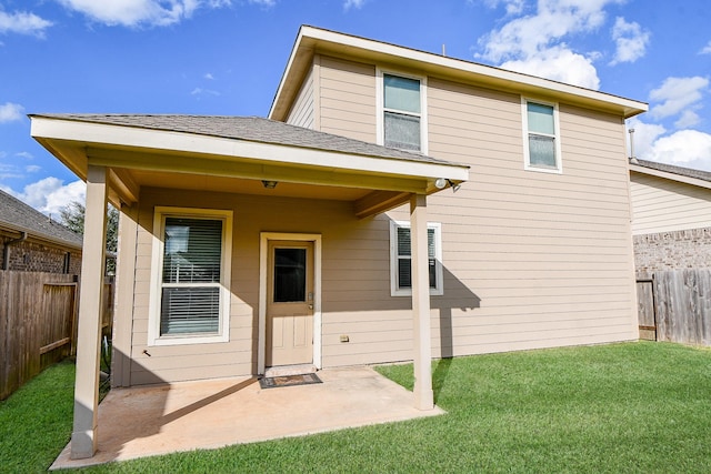 rear view of house featuring a lawn and a patio area