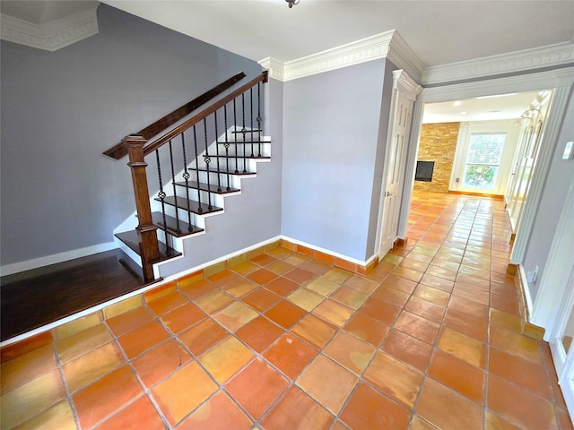 stairs with tile patterned flooring, a stone fireplace, and crown molding