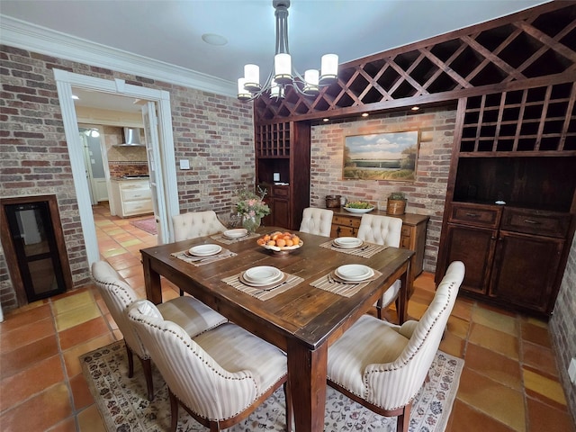 tiled dining area featuring an inviting chandelier, brick wall, and ornamental molding