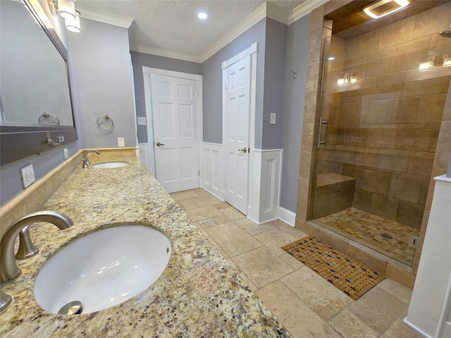 bathroom with crown molding, vanity, a textured ceiling, and walk in shower