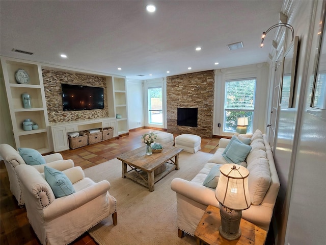 living room featuring a fireplace, light tile patterned floors, and built in features