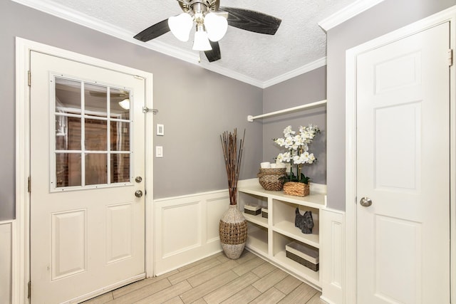 doorway to outside featuring a textured ceiling, ceiling fan, light hardwood / wood-style floors, and crown molding