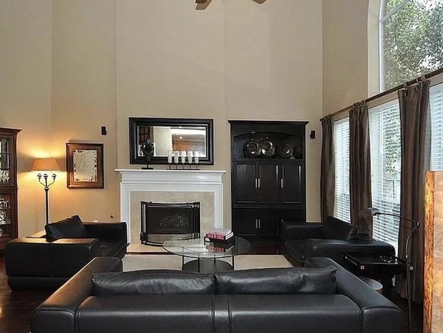 living room featuring ceiling fan, a towering ceiling, and a wealth of natural light