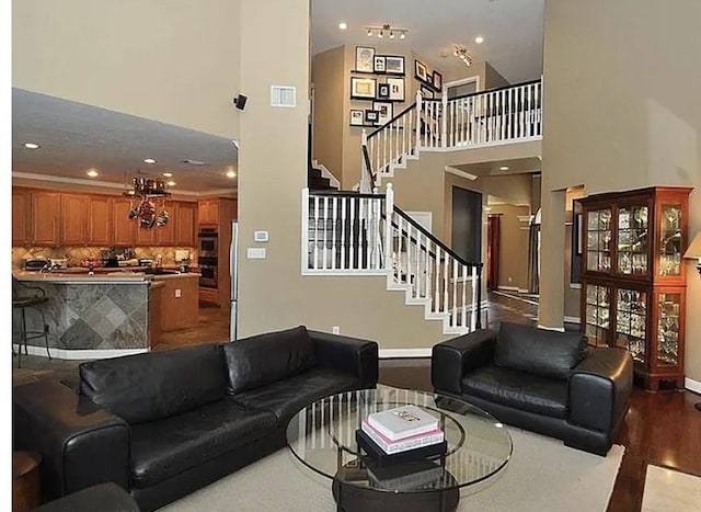 living room featuring a high ceiling, a notable chandelier, and hardwood / wood-style floors