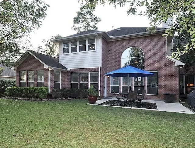 back of property with a yard and a patio