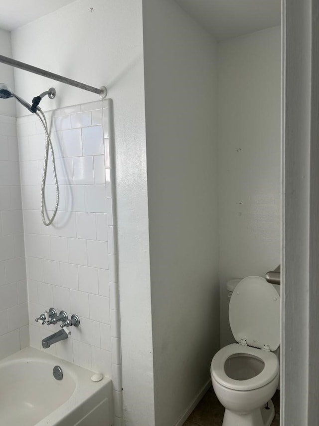 bathroom featuring tiled shower / bath combo and toilet