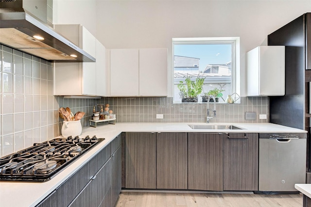 kitchen featuring dishwasher, white cabinets, sink, light wood-type flooring, and gas cooktop