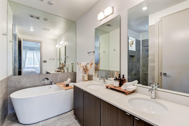 bathroom featuring tile patterned floors, vanity, and shower with separate bathtub