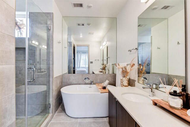 bathroom with tile patterned floors, plenty of natural light, vanity, and independent shower and bath